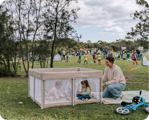 mummio portable safe space play pen at a soccer game with three children playing and mum on a picnic blanket